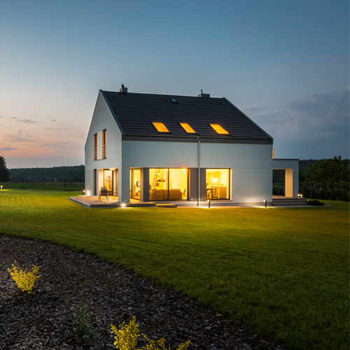 Brightly lit house and garden at night
